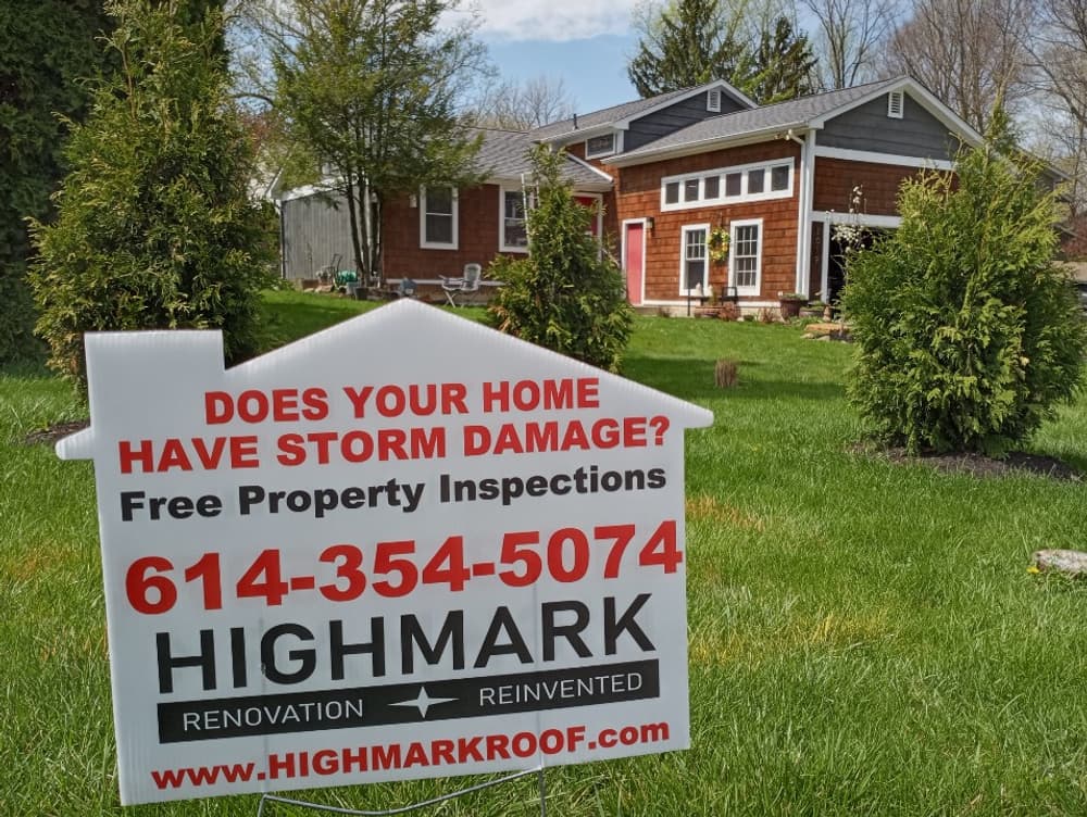 Sign for Highmark Roof offering free storm damage inspections in front of a home.